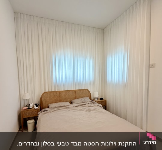 חדר שינה עם וילונות לבנים ומיטה זוגית